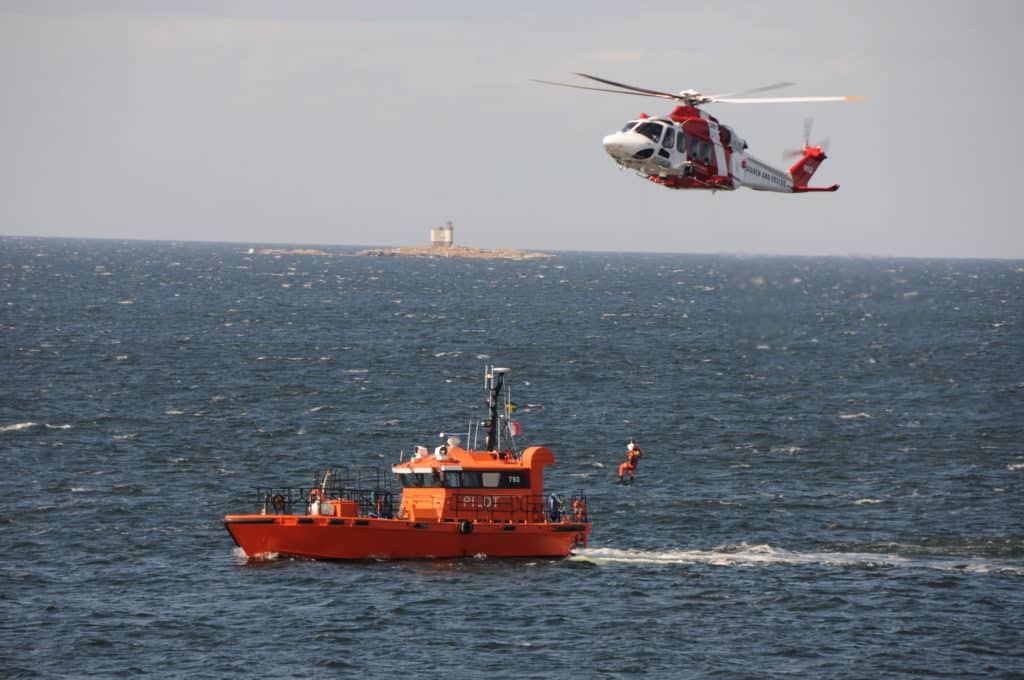 Winschning mellan lotsbåt och Sjöräddninghelikopter. Fyren Tjärven i bakgrunden